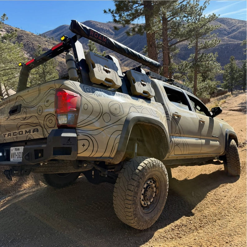Tan Toyota Tacoma with black topo vinyl wrap